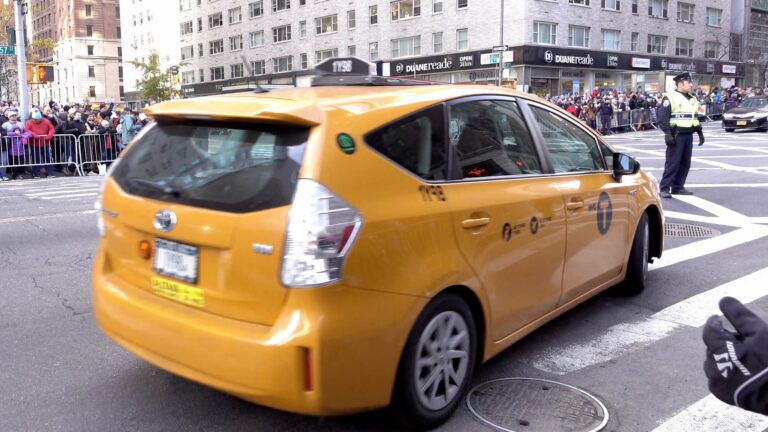 Yellow Prius car on busy city street.