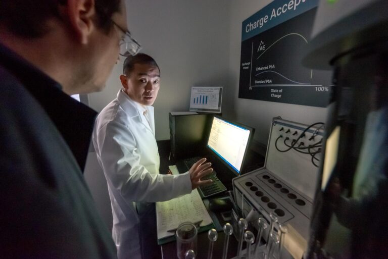 Man in lab coat with assistant at a computer screen